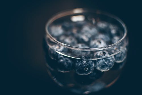 浆果漂浮在装满水的玻璃上 · 免费素材图片