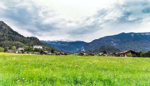 绿草田和白云下的山 · 免费素材图片