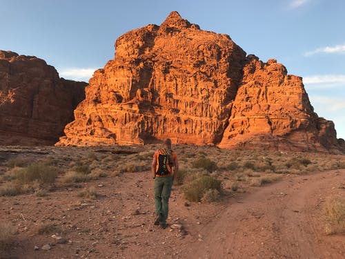 穿着橙色衬衫和绿色裤子的人 · 免费素材图片