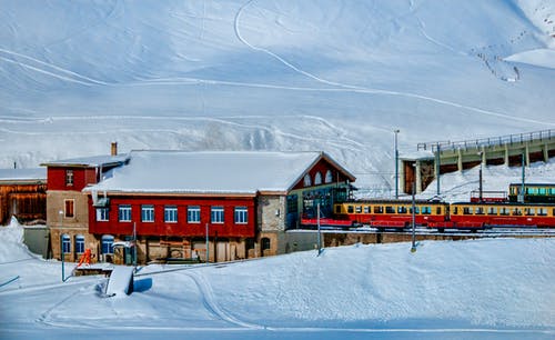 雪山旁的黄色和红色火车 · 免费素材图片