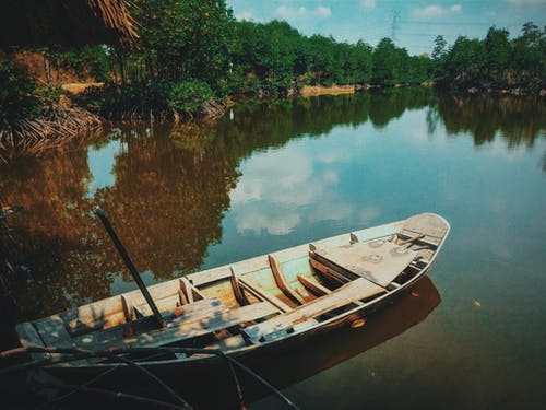 棕色独木舟船在水面上 · 免费素材图片