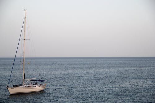 Cloufy白天在海洋上的白色游艇 · 免费素材图片