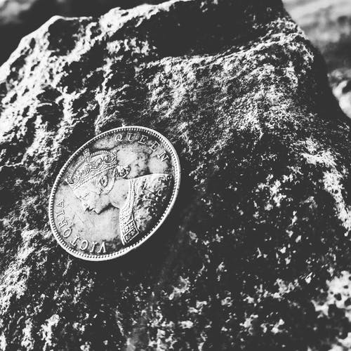 维多利亚女王硬币在岩石上的灰度照片 · 免费素材图片