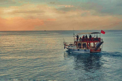 白天在海洋中的棕色和白色小船 · 免费素材图片