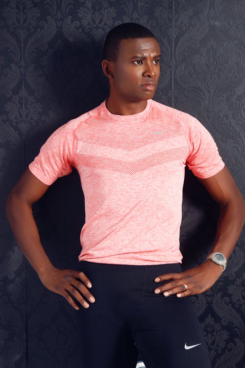 男人穿着粉红色圆领衬衫和黑色耐克短裤站 · 免费素材图片