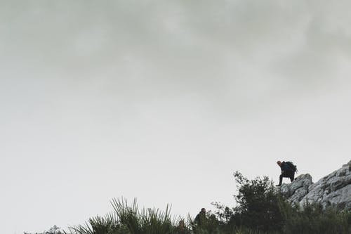 白多云的天空下落基山上的人 · 免费素材图片