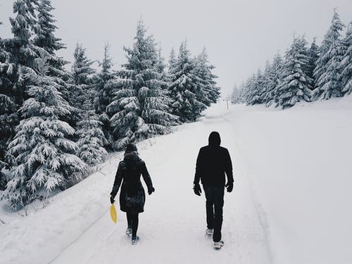 在白雪皑皑的设置在路中间的两个人的照片 · 免费素材图片