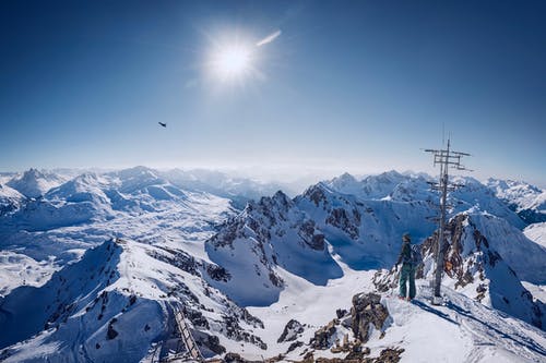 在湛蓝的天空下的白雪覆盖的山顶上的人 · 免费素材图片