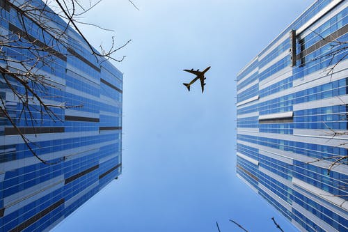 蓝色和灰色建筑附近的飞机 · 免费素材图片