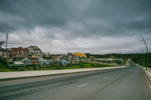 多云的天空下路边的村庄 · 免费素材图片