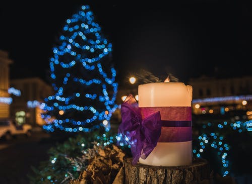 白色支柱蜡烛在登录的蓝色led发光圣诞树的距离 · 免费素材图片