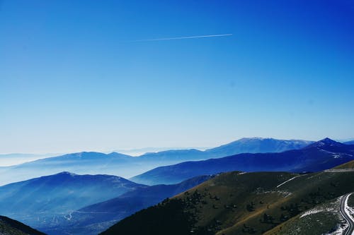 蓝天下的绿色和蓝色雾覆盖山 · 免费素材图片