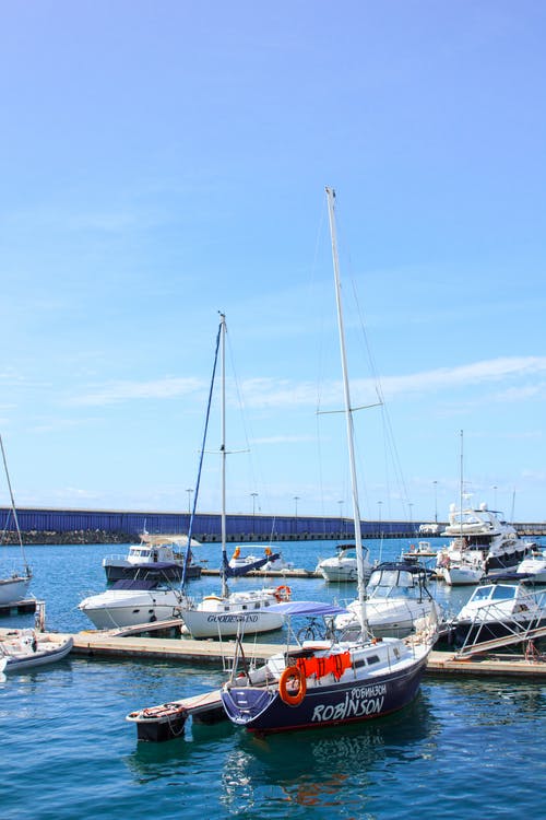 码头旁的白色和黑色鲁滨逊游艇 · 免费素材图片