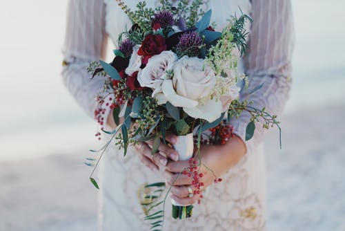女人抱着红色和白色的玫瑰花束 · 免费素材图片