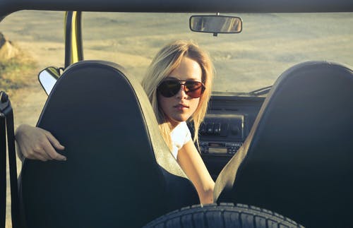 戴着墨镜骑在车里的女人 · 免费素材图片