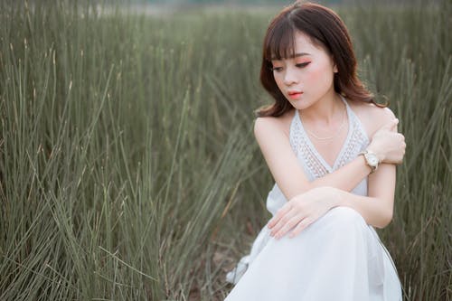 女人穿着草环绕的白色吊带裙 · 免费素材图片