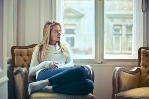 女人坐在窗边的椅子上的摄影 · 免费素材图片