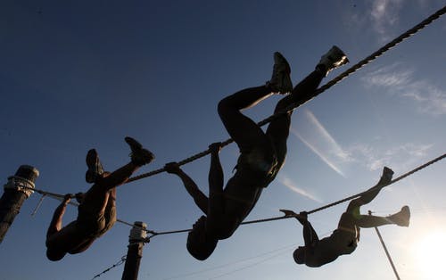 三名男子在夕阳下的绳索上攀爬 · 免费素材图片
