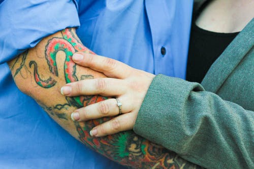 纹身的男人和一个女人在绿色上衣 · 免费素材图片