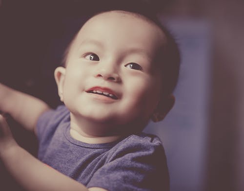 一个微笑的婴儿的特写摄影 · 免费素材图片