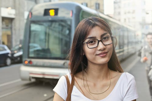 白衬衫和眼镜站在火车旁边的女人 · 免费素材图片
