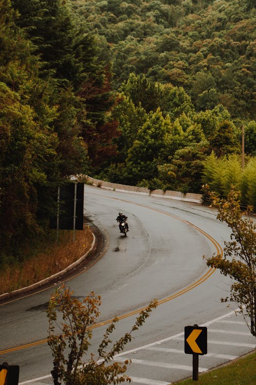 男子骑摩托车在路上 · 免费素材图片