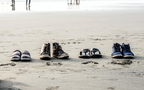 什锦双鞋在沙滩上的照片 · 免费素材图片