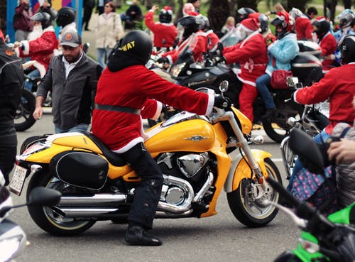 圣诞老人西装骑黄色巡洋舰摩托车的人 · 免费素材图片