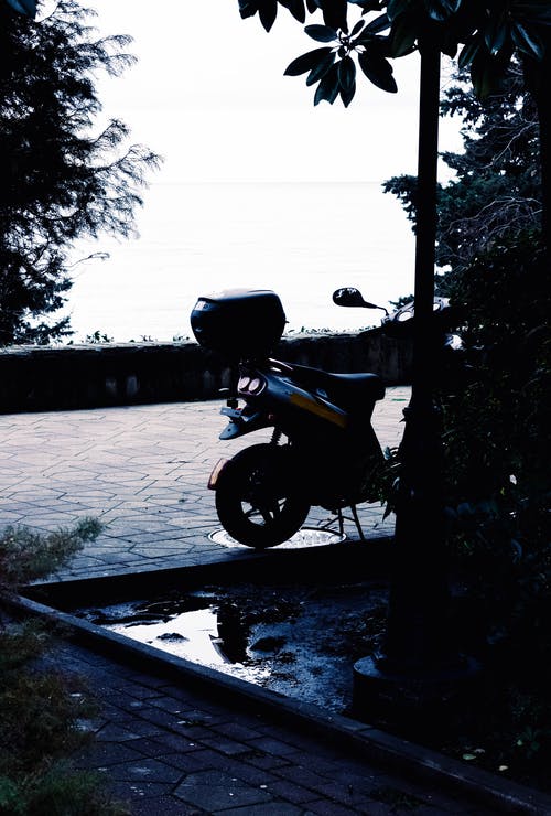 灰色和黄色的小型摩托车，在白天的灯柱附近 · 免费素材图片