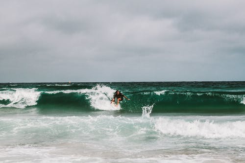 在海浪上冲浪的人 · 免费素材图片