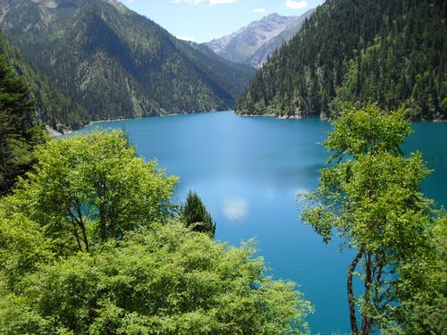 蓝色的水体和绿色的山脉长时间曝光摄影 · 免费素材图片