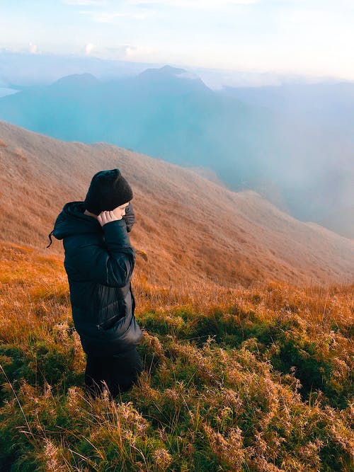 身穿黑色外套站在草地上的男人 · 免费素材图片
