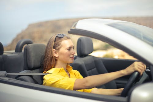 驾驶一辆银色汽车的黄色衬衫的女人 · 免费素材图片