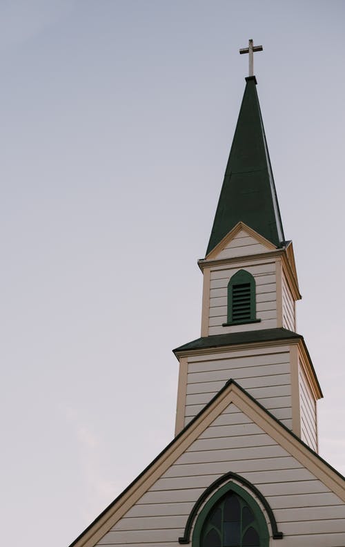 白色和绿色教堂的钟楼在晴朗的天空下的建筑摄影 · 免费素材图片