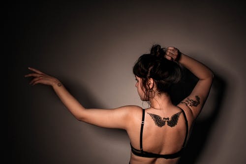 鹰纹身背穿黑色胸罩的女人 · 免费素材图片