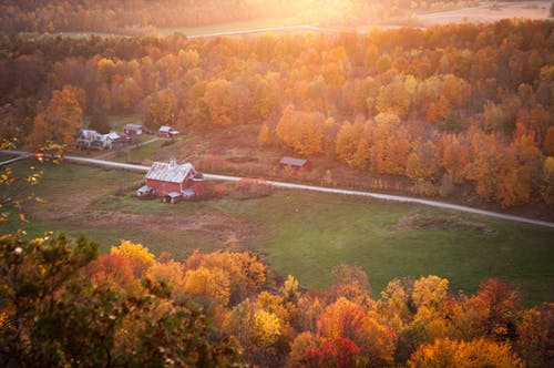 绿草场附近的红色和白色彩绘的谷仓的鸟瞰图 · 免费素材图片