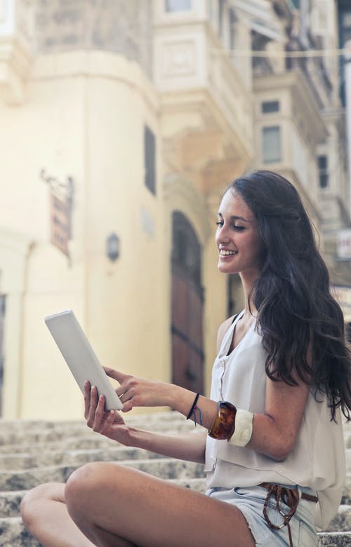 一个女人坐在楼梯上的照片 · 免费素材图片
