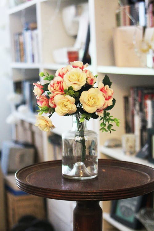 桌上的透明玻璃花瓶中的花瓣花的安排 · 免费素材图片