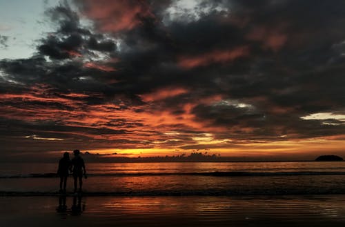 两人站在海滩剪影照片 · 免费素材图片