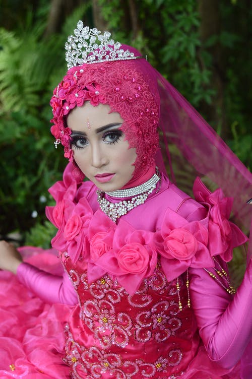 女人穿带皇冠的粉红色长袖连衣裙 · 免费素材图片