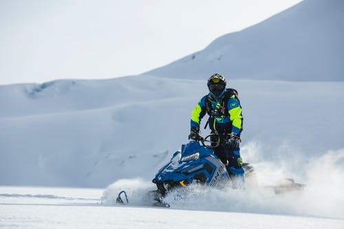 白天，人骑在蓝色雪地车上 · 免费素材图片