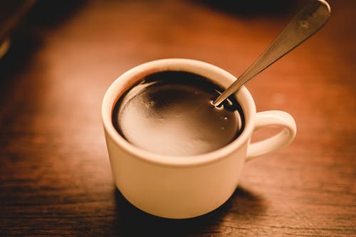 白色陶瓷咖啡杯子装满咖啡棕色木制表面上 · 免费素材图片
