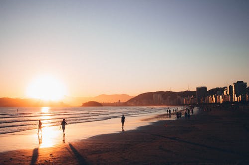 黄金时段在海边散步的人 · 免费素材图片