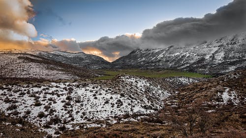 多云的天空下白雪覆盖的山脉的风景摄影 · 免费素材图片