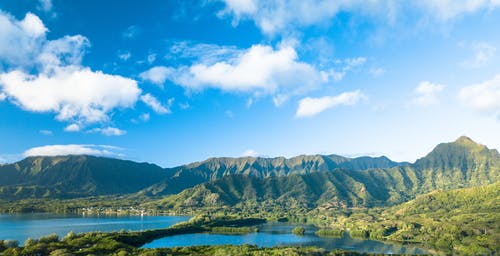 在蓝天白云下的绿色森林山脉 · 免费素材图片