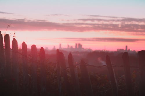 日落期间白色木栅栏的摄影 · 免费素材图片