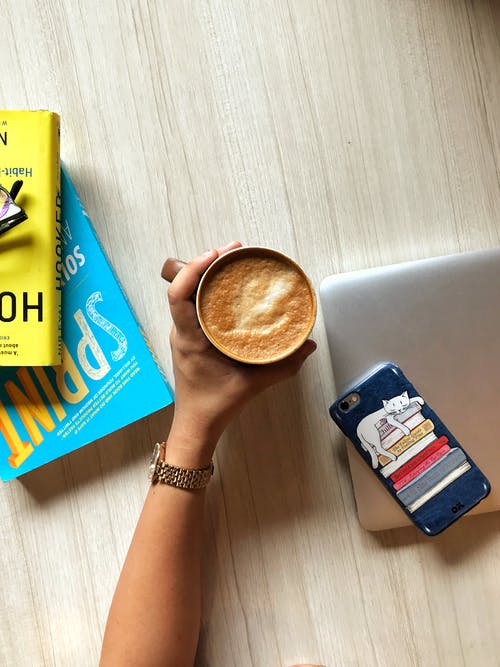 拿着一杯装满卡布奇诺咖啡的人 · 免费素材图片