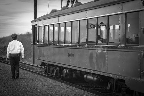 女人旁边的火车的灰度摄影 · 免费素材图片