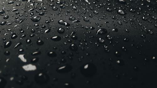 黑色表面上的雨滴的微距摄影 · 免费素材图片