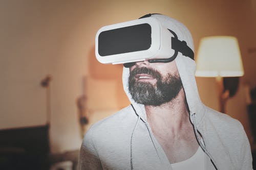 戴灰色帽衫和白色虚拟现实耳机的人 · 免费素材图片